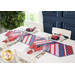 Table runner made of strips of alternating diagonal fabrics in red, white, and blue featuring patriotic motifs.