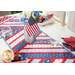 Table runner made of strips of alternating diagonal fabrics in red, white, and blue featuring patriotic motifs.