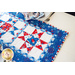 Geometric able runner made of patriotic summer themed fabrics in red, white, and blue.