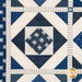 Quilt with geometric designs of squares and diamonds in blue and cream fabrics.