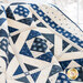 Quilt with geometric designs of squares and diamonds in blue and cream fabrics.