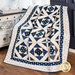 Quilt with geometric designs of squares and diamonds in blue and cream fabrics.