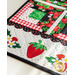 Table runner made of strawberry themed fabrics and featuring strawberry shaped appliqué on the ends.