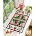 Table runner made of strawberry themed fabrics and featuring strawberry shaped appliqué on the ends.