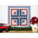 Wall hanging made of strips of red white and blue fabric featuring florals, paisleys, and gingham prints.