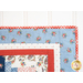 Wall hanging made of strips of red white and blue fabric featuring florals, paisleys, and gingham prints.