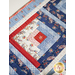 Table runner with square designs made with strips of red, white, and blue fabric featuring floral, paisley, and gingham prints.