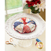 Round pin cushion made from triangle pieces of fabric with patriotic embroidery and a button middle.