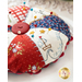 Round pin cushion made from triangle pieces of fabric with patriotic embroidery and a button middle.