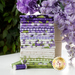 A photograph of a stack of the fabrics included in the 24 fq set, staged with greenery and purple flowers.