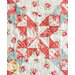 A patterned quilt featuring floral and polka dot designs in red, teal, and cream colors.