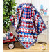 A colorful patchwork quilt in red, white, and blue draped over a chair, with decorative elements around.