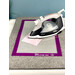 An iron sits on a gray mat with a pink fabric square and a purple border, labeled Appli-Fuse Mat.