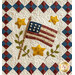 Quilt featuring an American flag, yellow stars, and green leaves against a diamond-patterned border.