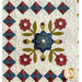 Colorful quilt featuring floral appliqué in the center and a patterned border of squares.
