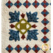 Colorful quilt featuring floral and leaf patterns in blue, red, and green, with a textured background.