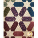 Colorful quilt featuring hexagonal patterns in green, blue, burgundy, and cream on a textured background.