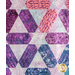 A colorful quilt featuring hexagonal patterns in shades of purple, pink, and blue with intricate stitching.