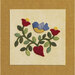 Colorful appliqué design featuring a blue bird perched among red flowers and green leaves on a beige background.