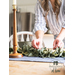 Woman setting a table with a faux sage leaf centerpiece