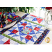 A red, white, blue, and green geometric table runner quilt block made of floral fabrics