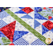 A red, white, blue, and green geometric table runner quilt block made of floral fabrics