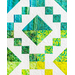 Colorful quilt featuring geometric patterns in shades of green and blue against a white background.