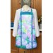 Apron with a bright floral design featuring various colorful hydrangeas against a light background, displayed on a mannequin.