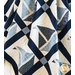 Quilt featuring blocks of geometric sail boats made of white and blue fabrics draped over furniture.