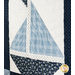 Quilt block of geometric sail boat made of white and blue floral fabrics.