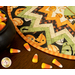Folded star table topper with whimsical halloween prints in orange, cream, and green.