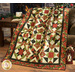 A quilt with a colorful geometric pattern drapes over a chair beside a cozy fireplace.