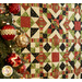 A colorful quilt featuring geometric patterns in red, green, and black hangs beside a decorated Christmas tree.