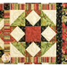 Close-up of a quilt featuring a geometric pattern in red, cream, green, and black with floral accents.