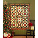 A festive quilt with geometric patterns hangs on a green wall, next to a decorated Christmas tree.