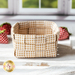 Basket made of woven neutral plaid fabrics surrounded by strawberries made of fabric.