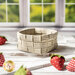 Basket made of woven neutral plaid fabrics surrounded by strawberries made of fabric.