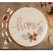 Embroidery hoop with hand embroidery featuring florals and the word home.