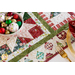 Close up of table runner decor showing the edge of a gold place setting and a bowl of Christmas ornaments.