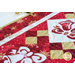 Christmas themed table runner featuring bell designs made of red and cream snowflake fabrics.