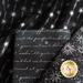 Close up of black fabric with metallic silver winter motifs layered atop one another