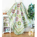 Quilt filled with sawtooth stars and flower appliqué in pastel green and purple colors.