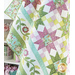 Quilt filled with sawtooth stars and flower appliqué in pastel green and purple colors.