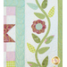 Close up of flower appliqué in pastel green and purple fabrics.
