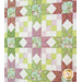 Quilt filled with sawtooth stars and flower appliqué in pastel green and purple colors.