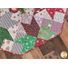 Tree skirt with patchwork and geometric star design made of red, white, and green, Christmas themed fabrics.