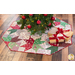 Tree skirt with patchwork and geometric star design made of red, white, and green, Christmas themed fabrics.