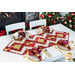 Table runner with strips of fabric in a lattice design made from metallic red and cream Christmas and snowflake printed fabrics.