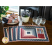 Placemats with log cabin rectangular strip design featuring a pocket for silverware and red, blue, and cream fabric prints.