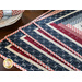 Placemats with log cabin rectangular strip design featuring a pocket for silverware and red, blue, and cream fabric prints.